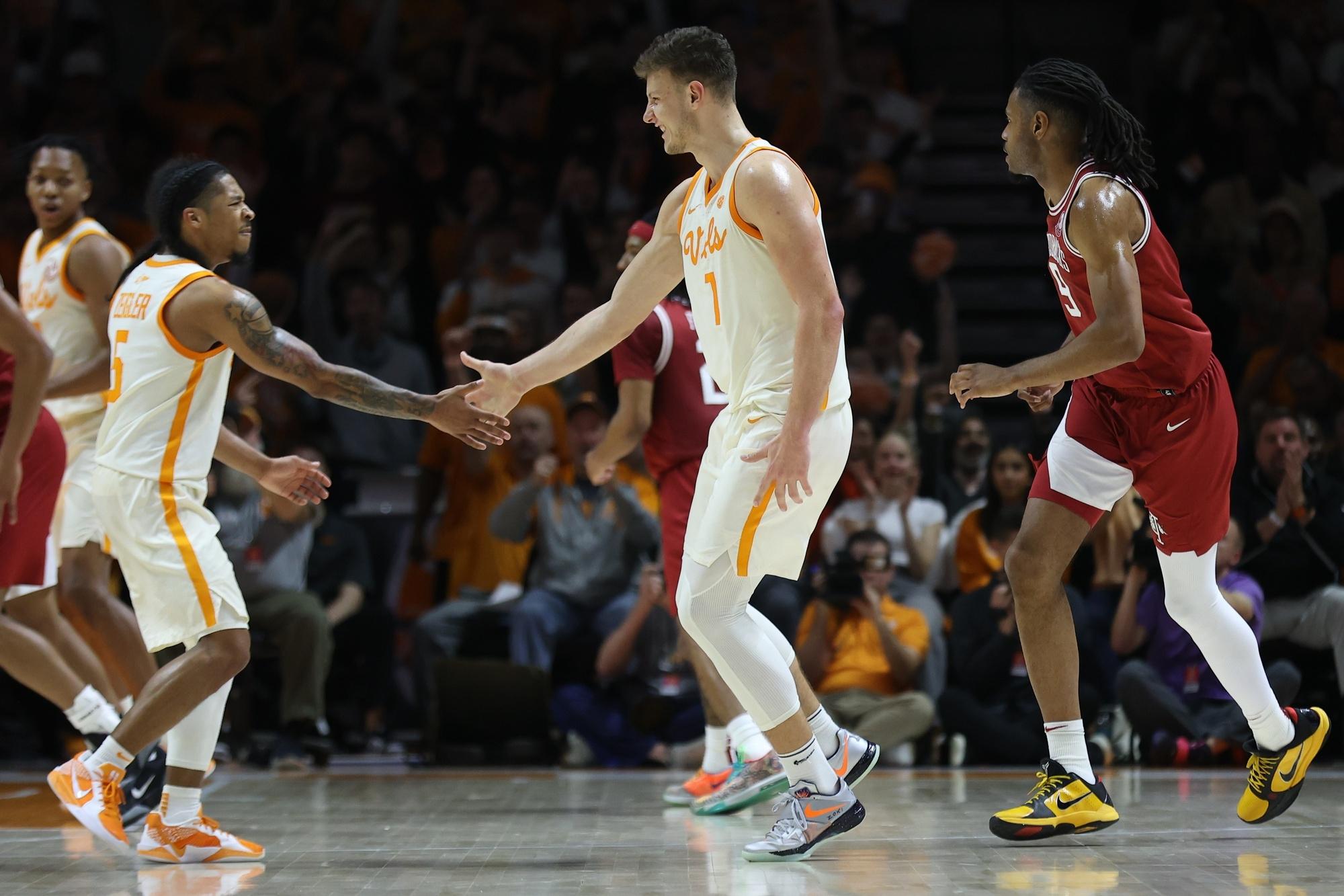 Tennessee's Zakai Zeigler and forward Igor Milicic Jr. dap up against the Arkansas