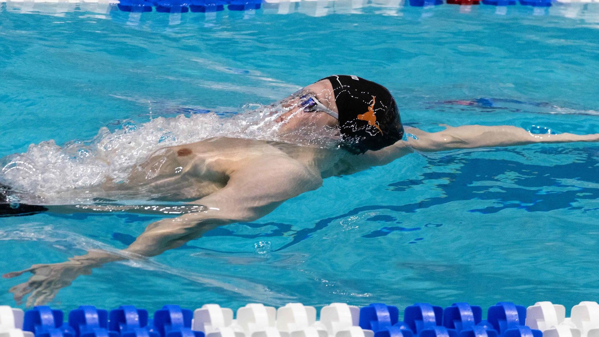 Texas swimmer breaking the surface of the water with cap